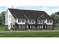 Modern three-story townhome with gray and brick exterior, and a grassy lawn at 2411 Adrift Rd, Fuquay Varina, NC 27526