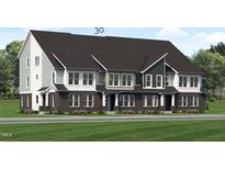 Modern three-story townhome with dark brick and light siding at 2413 Adrift Rd, Fuquay Varina, NC 27526