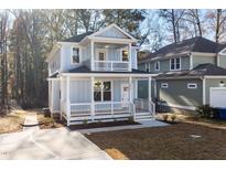 Two-story light blue house with white trim, front porch, and small yard at 306 Cecil St, Durham, NC 27707