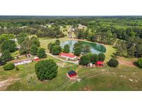 Aerial view of a house, pond, and multiple outbuildings at 23 Furney Pearce Rd, Zebulon, NC 27597