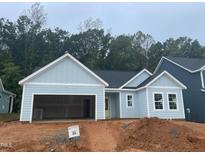 Newly constructed light blue house with a two-car garage at 1063 Grey Flint Pl # 35, Mebane, NC 27302