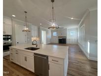 Open concept kitchen with island, stainless steel appliances, and hardwood floors at 909 Lily Claire Ln, Fuquay Varina, NC 27526