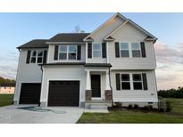 Two story home with a two car garage and landscaped yard at 223 Bonsai Way, Four Oaks, NC 27524