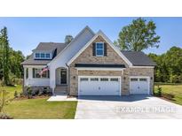 Two-story house with stone accents and a three-car garage at 5021 Trotter Dr, Raleigh, NC 27603