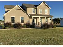 Two story home with light beige siding and landscaping at 8309 Walking Fern Ct, Willow Springs, NC 27592