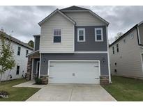 Two-story house with gray and white siding, a two-car garage, and a landscaped lawn at 136 Anise Tree Way, Clayton, NC 27527