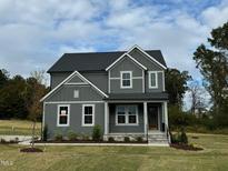 Two story home with gray siding, landscaping, and stone accents at 230 Grading Stick Ct, Angier, NC 27501