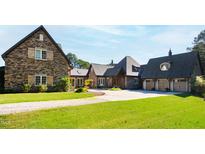 Stone and shingle exterior of a luxurious home with a large driveway and manicured lawn at 3700 Lark Farm Rd, Franklinton, NC 27525
