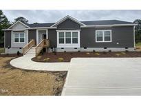 Modern single-story home with gray siding, landscaped yard, and concrete driveway at 6733 Oscar Barham Rd, Wake Forest, NC 27587