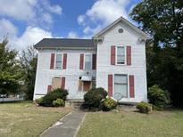 Two-story Victorian home with wood siding, shutters, and a walkway at 414 E Morehead St, Burlington, NC 27215