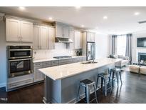 Modern kitchen with gray cabinets, quartz countertops, and island at 10420 Sablewood Dr # 115, Raleigh, NC 27617