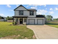 Two-story home with white siding, black accents, and a two-car garage at 3241 Plain View Hwy, Dunn, NC 28334