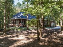 Brick house nestled in a wooded lot with a large front porch at 2008 Neuse Colony Dr, Clayton, NC 27527