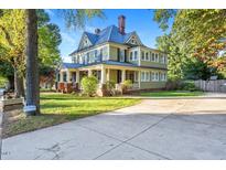 Large two-story house with a wrap-around porch and brick accents at 26 Oak St, Roxboro, NC 27573