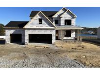 New construction home with brick exterior, two-car garage, and covered porch at 202 Golden Leaf Farms Rd, Angier, NC 27501