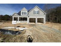 Two-story home with gray siding, a three-car garage, and a spacious front yard at 373 Abingdon Farms Dr, Selma, NC 27576