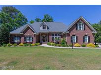 Brick home with a large lawn and mature trees at 512 W Franklin St, Zebulon, NC 27597