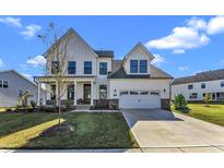 Two-story farmhouse with white siding, gray roof and a two-car garage at 616 Silver Comet Dr, Knightdale, NC 27545