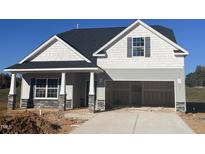 New construction home with gray siding, stone accents and a two-car garage at 207 Wildwood Ln, Graham, NC 27253