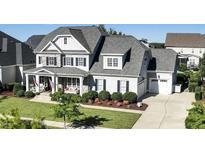 Two-story home with stone accents, welcoming porch, and landscaped yard at 117 Hardy Oaks Way, Holly Springs, NC 27540
