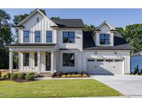 Two story farmhouse style home with a large driveway at 6045 Scalybark Road, Durham, NC 27712
