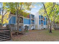 Two-story building with blue siding, multiple balconies, and stairs leading to the entrance at 7040 Longstreet Dr # C, Raleigh, NC 27615