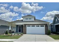 Brick home with a two-car garage and landscaping at 124 Swain St, Clayton, NC 27527