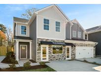 Two-story home with gray and beige siding, stone accents, and a two car garage at 724 Apple Churn Dr, Fuquay Varina, NC 27526