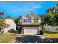Two-story house with stone and vinyl siding, a double garage, and landscaping at 3122 Genlee Dr, Durham, NC 27704