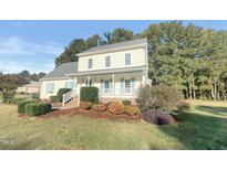 Two-story house with light yellow siding, gray roof, and a covered porch at 3181 Hardie St, Creedmoor, NC 27522