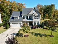 Two-story house with a three-car garage and landscaped yard at 5356 Cypress Ln, Raleigh, NC 27609