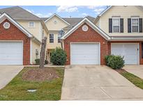 Brick front of townhome with attached garage and landscaping at 2633 Vega Ct, Raleigh, NC 27614