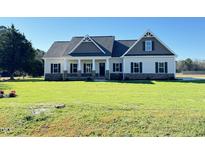 Newly built home with gray and beige siding, stone accents, and a grassy yard at 605 Quarterhorse Rd, Princeton, NC 27569