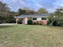 Brick ranch home with a well-maintained lawn at 733 Carlisle St, Raleigh, NC 27610