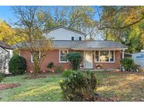 Brick ranch house with a black roof and landscaped yard at 110 Starlite Dr, Carrboro, NC 27510