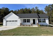 One-story house with white siding, a two-car garage, and a covered porch at 79 Tulipfield Way, Benson, NC 27504