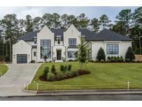 Two story home with white brick, black roof, and landscaping at 013 Bartley Holleman Rd # 13, New Hill, NC 27562