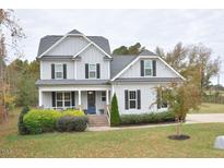 Two-story home with gray siding, brick accents, and a welcoming front porch at 30 Willow Bend Dr, Youngsville, NC 27596