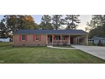 Brick ranch house with red shutters and carport at 4631 Bennett Memorial Rd, Durham, NC 27705