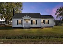 White one-story house with a spacious lawn and a tranquil setting at 2494 Joel Johnson Rd, Lillington, NC 27546