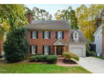 Brick home with a gray garage, shutters, and landscaping at 2257 Brisbayne Cir, Raleigh, NC 27615