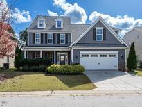 Two-story home with gray siding, white trim, and a three-car garage at 137 Castello Way, Clayton, NC 27527