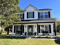 Two-story house with white siding, black accents, and a welcoming front porch at 3024 Tuckland Dr, Raleigh, NC 27610
