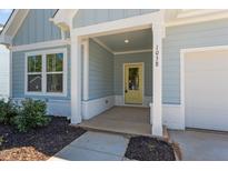 Inviting front porch with light blue exterior and yellow door at 1038 Grey Flint Pl, Mebane, NC 27302
