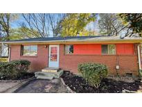 Brick ranch house with red accents, steps, and landscaping at 720 Darby St, Raleigh, NC 27610