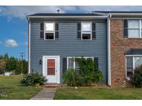 Brick and gray two-story townhome with landscaping and a red front door at 1812 Orange Grove Rd # 101, Hillsborough, NC 27278