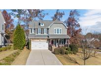 Two-story home with gray siding, stone accents, and a front porch at 2618 Needle Pine Dr, Apex, NC 27539