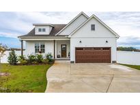 White farmhouse exterior with brown garage door and landscaping at 181 Glenwood Pl, Kenly, NC 27542