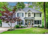 Two-story house with white brick exterior, landscaping, and a stone front porch at 5116 Elf Ct, Wake Forest, NC 27587