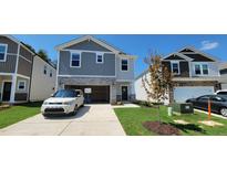 Two-story home with gray siding, stone accents, and a two-car garage at 1071 Cherry Stem Rd, Haw River, NC 27258